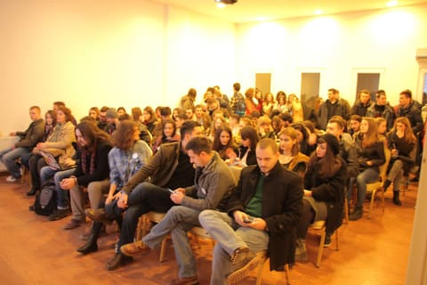 A full room of attendees, seen from the back